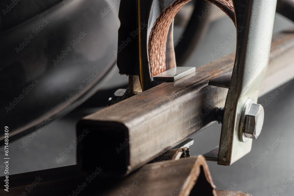 Welding mass clamp on the metal pipe close up background. Welding. Welding mass clamp on the metal pipe close up background. Welding.