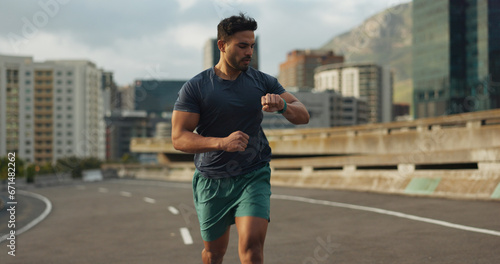 Running, road or man for time in training, practice or fitness goals for marathon competition. Indian athlete, wellness or speed runner in cape town race in watch progress, city street or health body