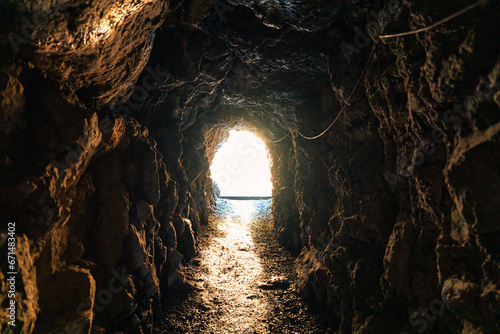 Natural cave mining underground tunnel rock and golden light at the destination