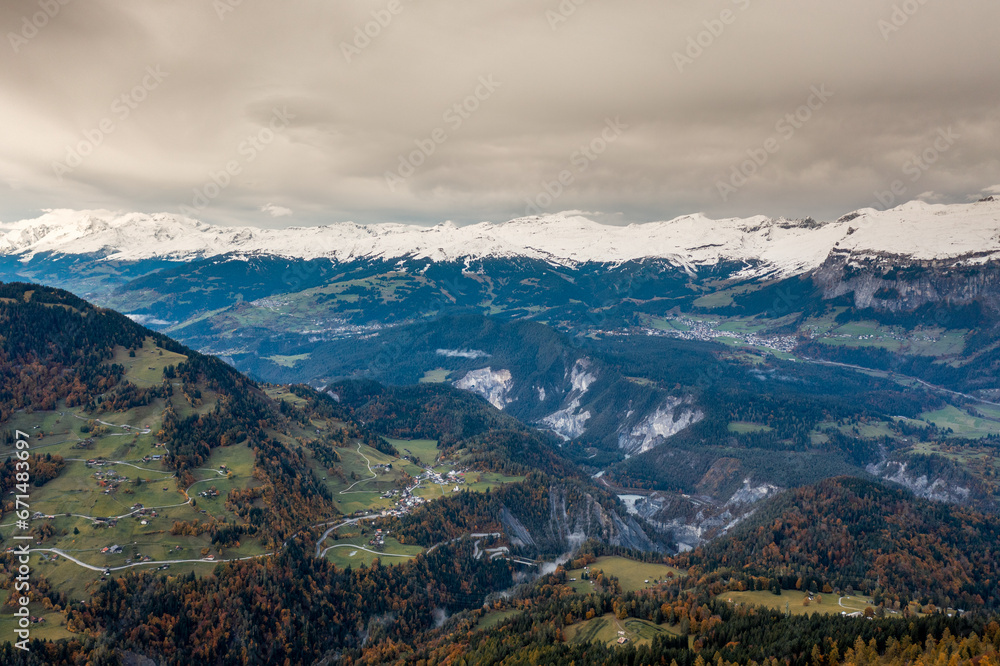 mountain landscape in the Swiss Alps with snow-capped peaks and autum color forest