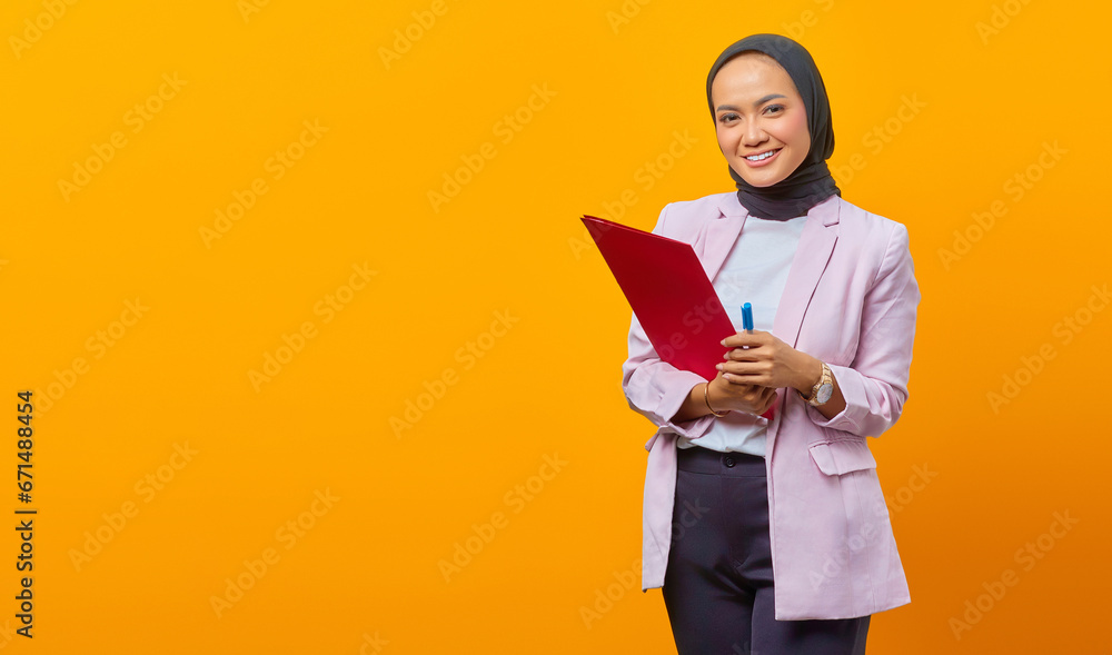 Beautiful asian woman holding folders and pen while looking at c Beautiful asian woman holding folders and pen while looking at c