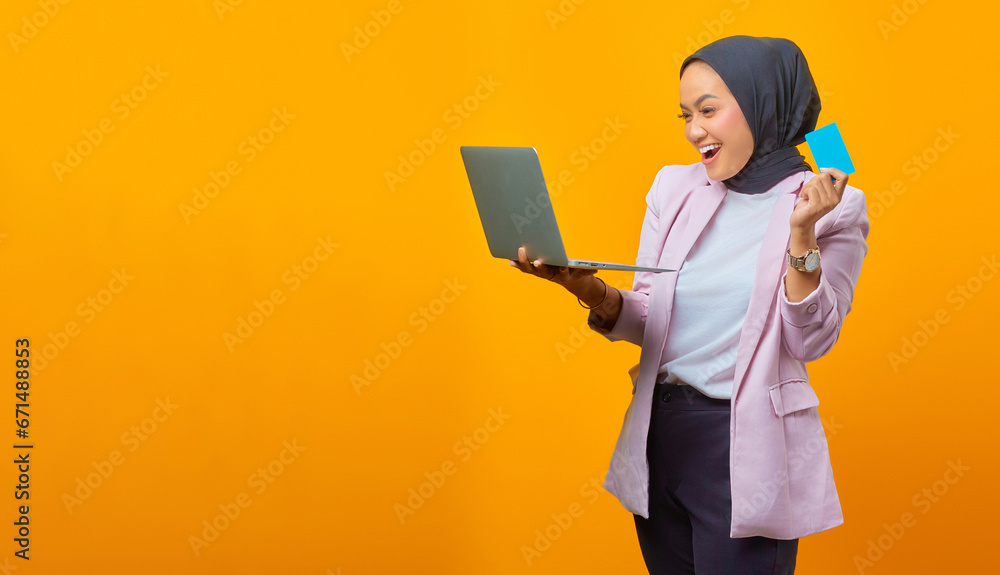 Cheerful asian woman holding laptop and showing blank card over Cheerful asian woman holding laptop and showing blank card over