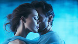 Beautiful lovers a woman and a man embrace on a blue background