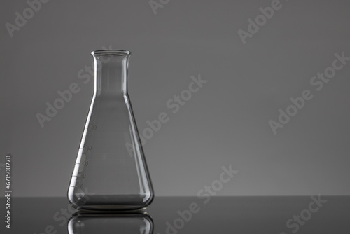 Close up of laboratory beaker and copy space on grey background