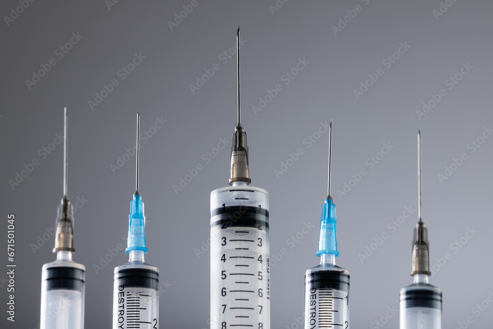 Close up of laboratory syringes with needles and copy space on grey background Close up of laboratory syringes with needles and copy space on grey background