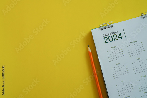 close up top view on white calendar 2024 with schedule of month and pencil to write or note and mark on important date for lifestyle and new year resolution concept