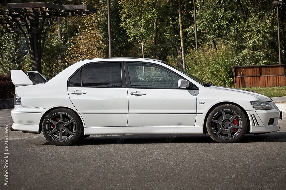 White car on a street background. Modern city sport car with a spoiler wallpaper