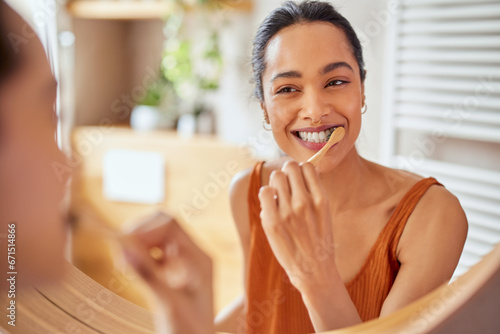 Young woman brushing teeth at home with toothbrush photo