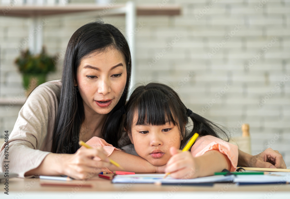 Portrait happy love asian family mother teach little daughter asian girl learn and study on table.Mom and asian young girl writing with book and pencil making lessons in homeschool at home.Education Portrait happy love asian family mother teach little daughter asian girl learn and study on table.Mom and asian young girl writing with book and pencil making lessons in homeschool at home.Education