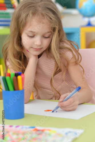 Portrait of cute girl drawing picture at home