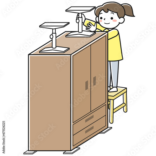 家具に転倒防止グッズを取り付ける女性