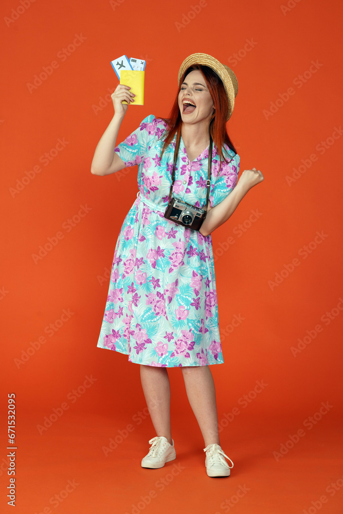 Woman holding flight tickets, passport and shouting happily with closed eyes and pumping fist, isolated on orange background Portrait of female traveler. Woman holding flight tickets, passport and shouting happily with closed eyes and pumping fist, isolated on orange background Portrait of female traveler.