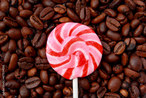 Lollipop candy on top of coffee beans as background