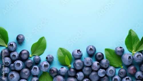 Fresh blueberries with green leaves on a blue background