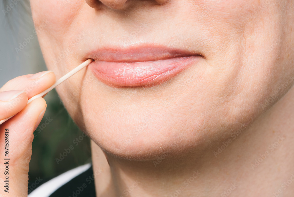 Obraz premium A beautiful woman holds a toothpick in her mouth. Oral hygiene. Healthy concept.