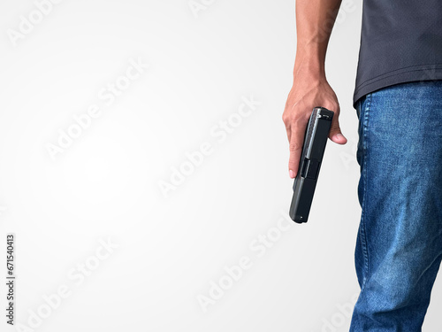 A man wearing a black short-sleeved shirt and jeans stands holding a handgun, symbolizing the killing of people, murder, Active shooting.