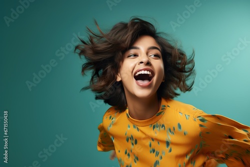 Portrait of a laughing modern young female of Indian ethnicity in playful mood