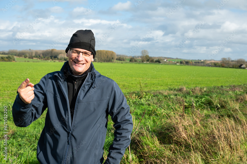 Active 45 yo white man with bonnet standing in the green fields around Gooik, Belgium Active 45 yo white man with bonnet standing in the green fields around Gooik, Belgium