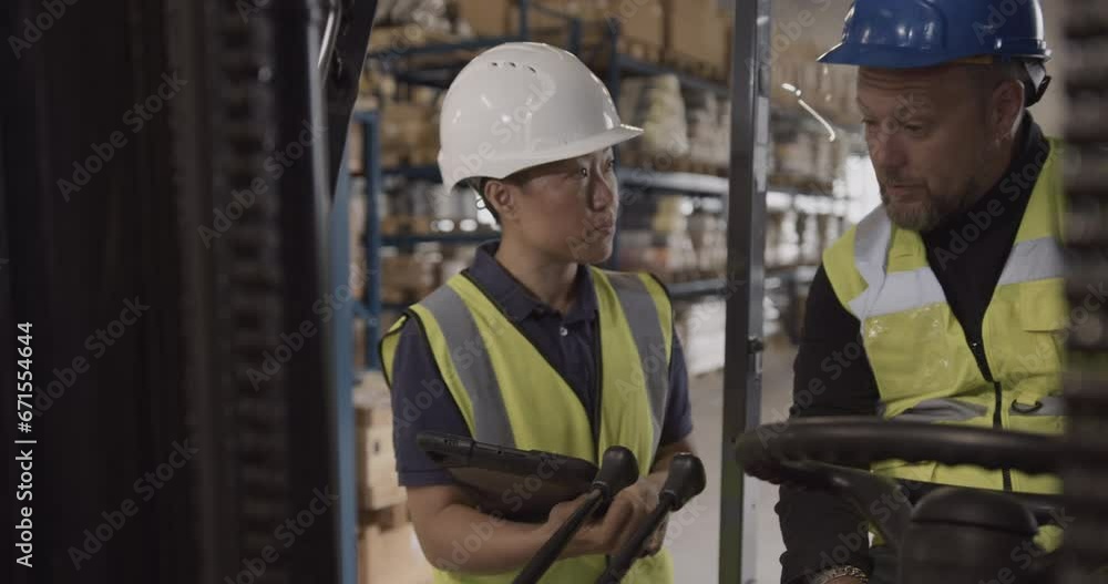 Two Warehouse Employees Looking at Digital tablet Discussing Supply chain Two Warehouse Employees Looking at Digital tablet Discussing Supply chain