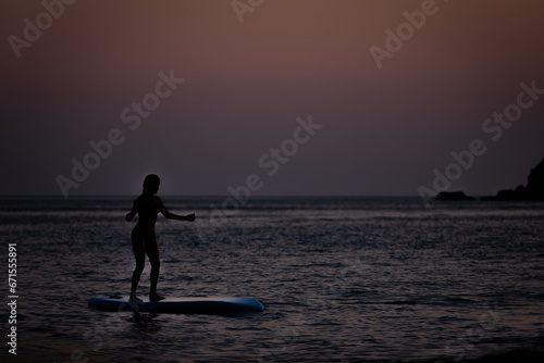 silhouette of a person with a surfboard