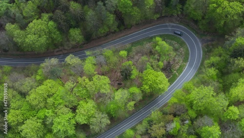 Van driving road with hairpin in forest, Steigerwald, Bavaria, Germany photo