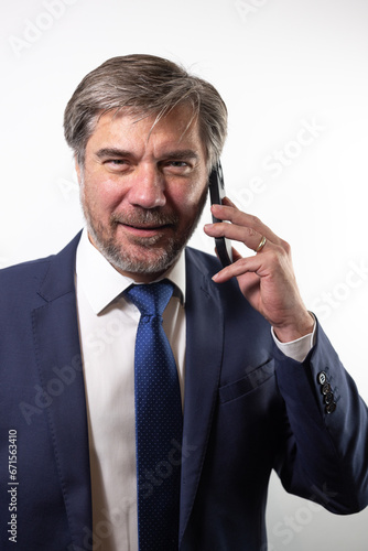 homme d'affaires, patron d'entreprise de 45 ou 50 ans qui téléphone avec un smartphone. Symbole de réussite professionnelle. Sur fond blanc.