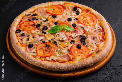 pizza with ham and mushrooms on black stone