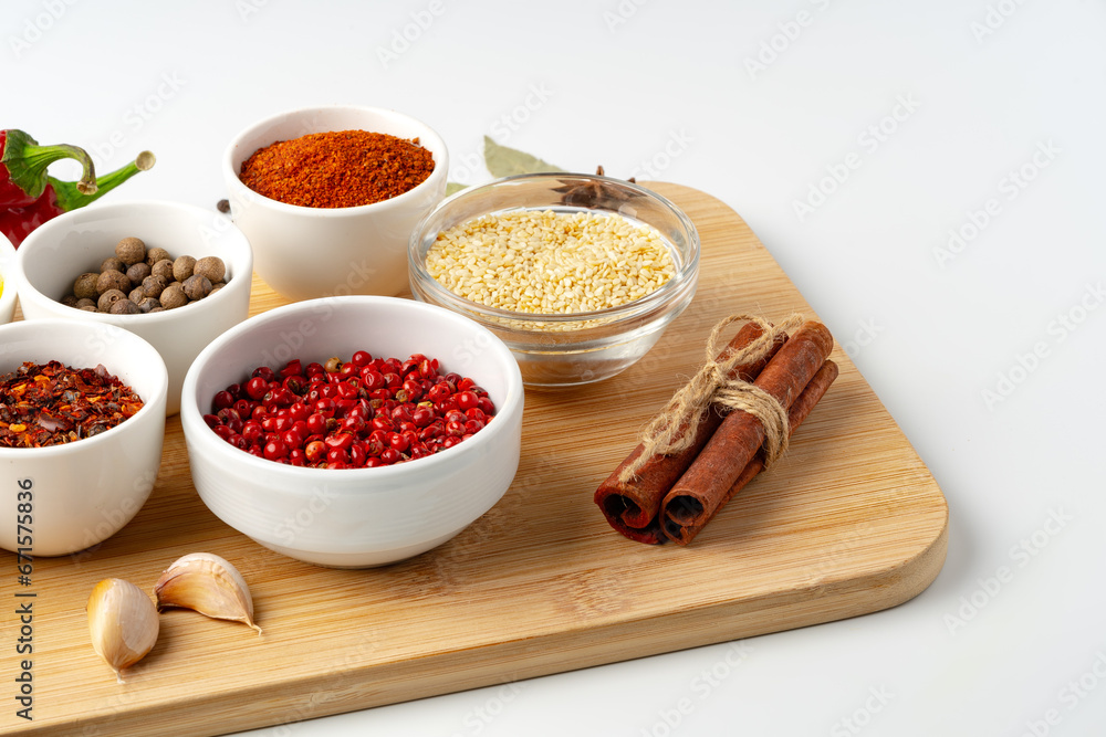 Bowls with spices on wooden board on white background Bowls with spices on wooden board on white background