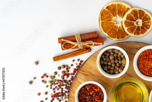 Bowls with spices on wooden board on white background