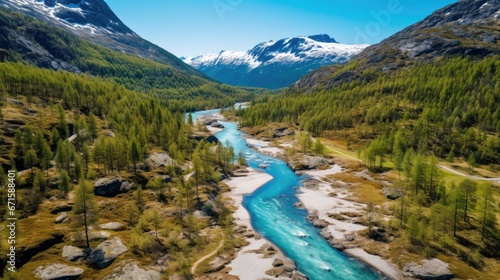 Drone high-angle photo of the turquoise-colored mountain river flowing in the pine woodland with a view of the mountain peaks in the background in Innlandet County, Norway
 photo