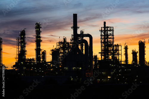 Silhouette of gas distillation of tank oil refinery plant tower oil of Petrochemistry industry on sky sunset