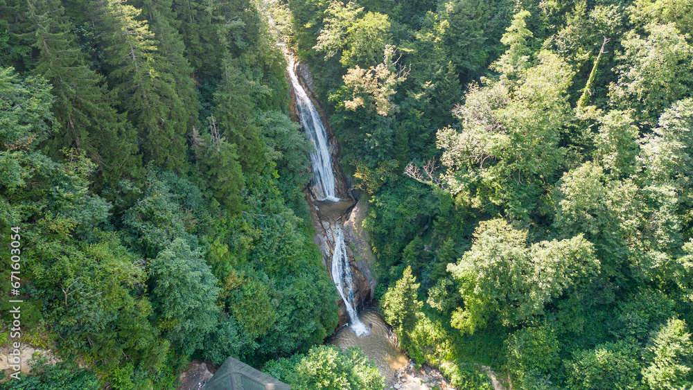 Fototapeta premium Waterfall flowing in the green forest. Local name manle waterfall. Aerial view