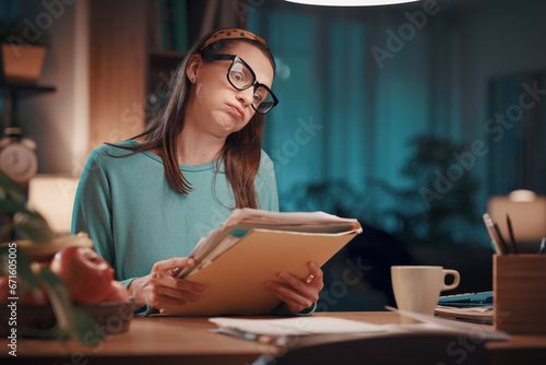 Frustrated woman checking paperwork at home photo