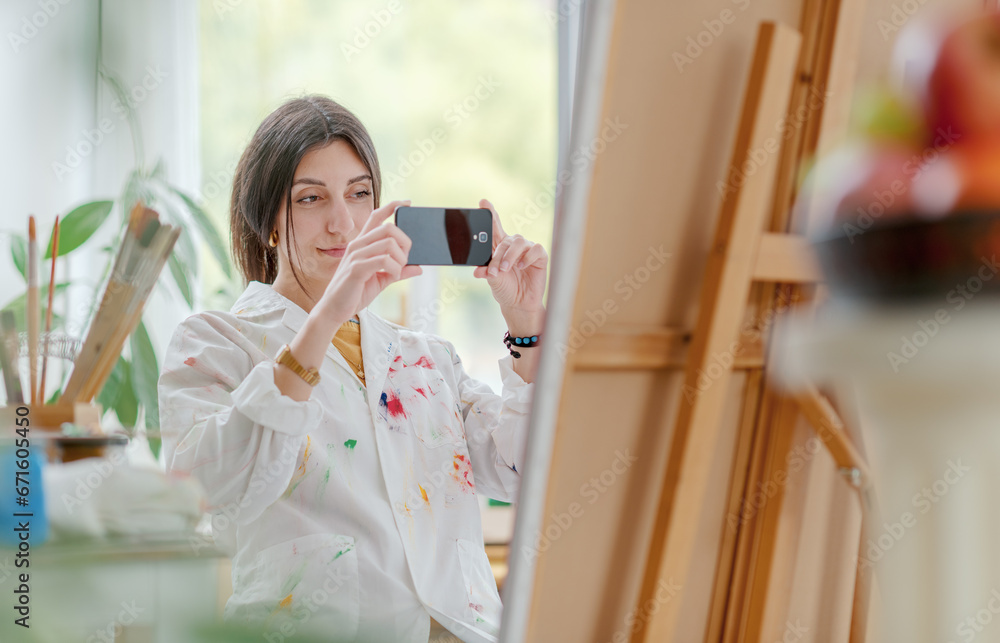 Naklejka premium Artist taking a picture of her painting