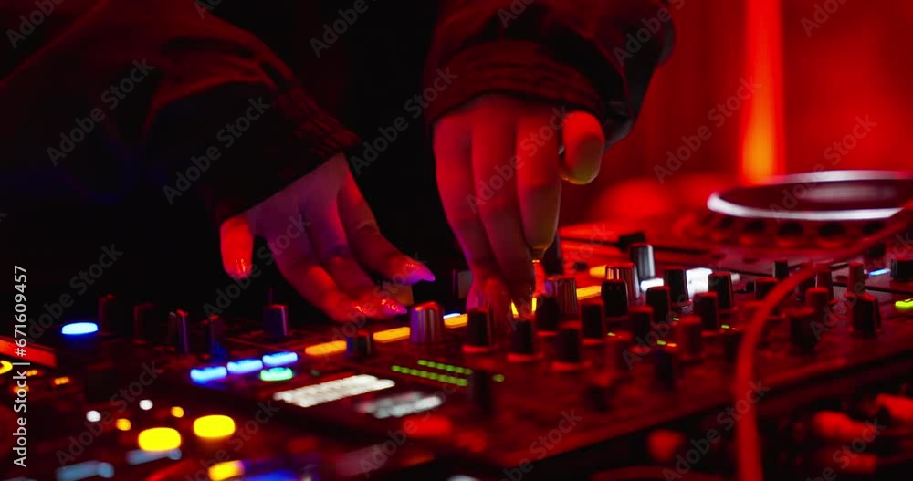 Close-up DJ Hand is adjusting fader on digital music console in neon light in nightclub. closeup. Concept of music on neon party.