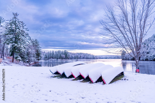 first snow fall of the year covers canoes on the shore of the ottawa river in morning