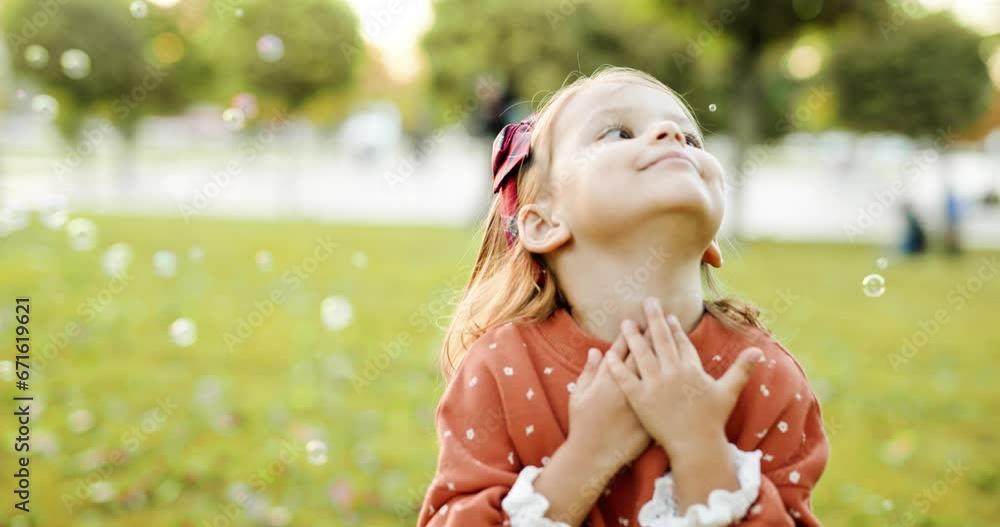 Cute little girl in an autumn park playing with soap bubbles on the grass. Toddler having fun outdoor. Autumn lifestyle photo for advertising tape. Cute little girl in an autumn park playing with soap bubbles on the grass. Toddler having fun outdoor. Autumn lifestyle photo for advertising tape.