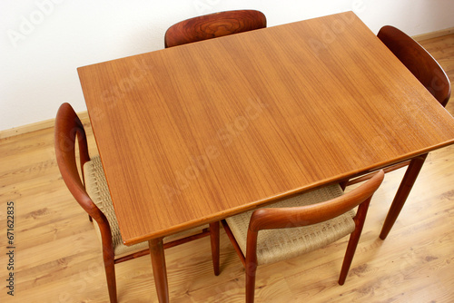 A mid century teak dining table with four chairs from the 50s 60s Danish Design Vintage Dining solid wood Modern antique 50s 60s isolated on white wall in modern living room closeup side front view