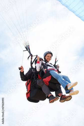 People, paragliding and smile in sky, together or extreme sport with freedom for fitness. Coach, partnership and person on adventure, helmet or fearless with backpack, parachute or portrait in clouds