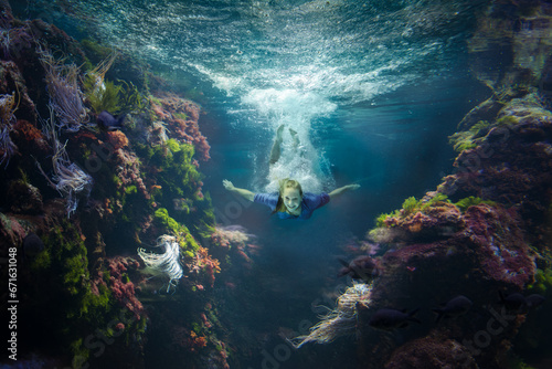 Unterwassercomposing Teenager taucht im bunten Korallenmeer