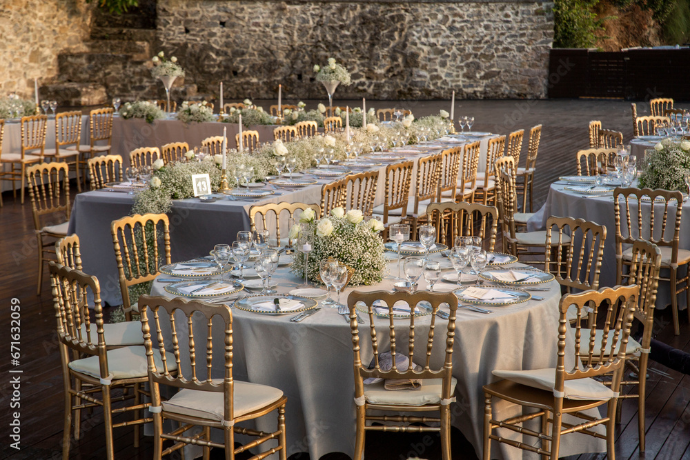 A luxurious, elegantly decorated wedding venue with a sea-view outdoor area. The decoration of the wedding venue features cream colors and tones, creating a very charming atmosphere with flowers.