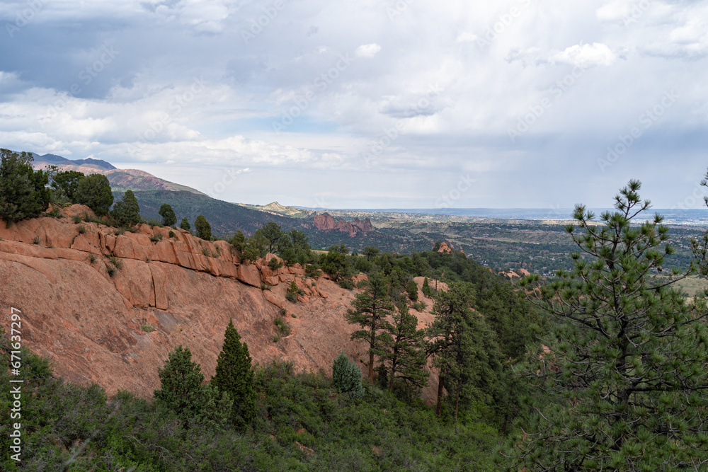 View of mountains, trees, and red rocks from Section 16 and Palmer Loop Hiking Trail in Colorado Spring, CO on a cloudy and overcast summer day View of mountains, trees, and red rocks from Section 16 and Palmer Loop Hiking Trail in Colorado Spring, CO on a cloudy and overcast summer day