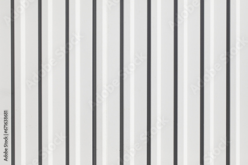 Corrugated metal sheet background. White paint metal stripes. Striped pattern. Garage door. Geometric lines metal wall.