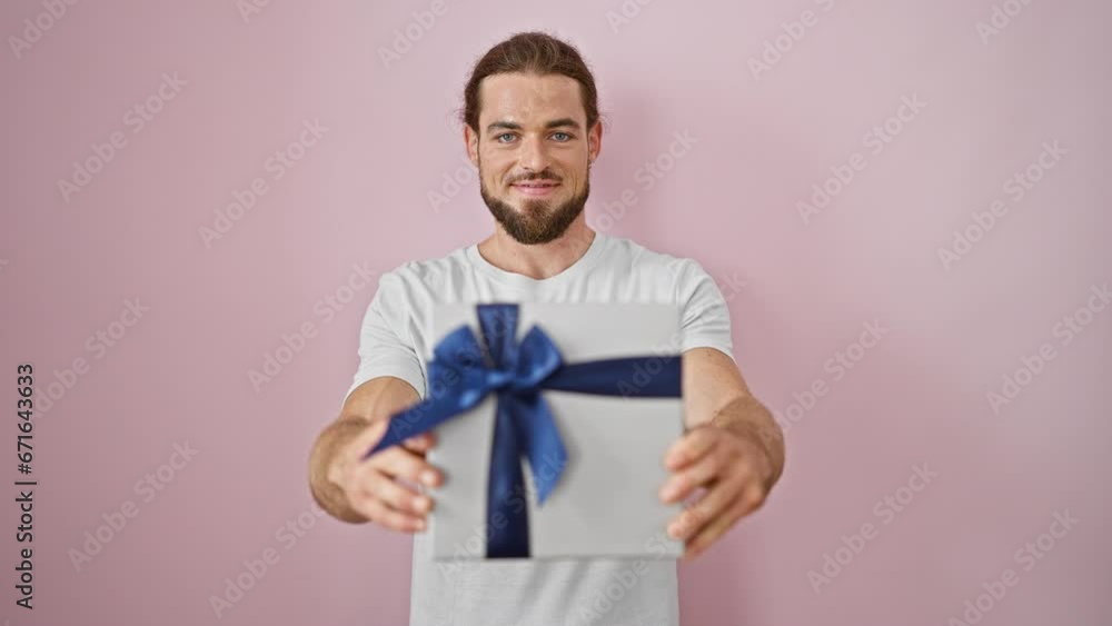 Young hispanic man smiling confident pointing to birthday gift over isolated pink background Young hispanic man smiling confident pointing to birthday gift over isolated pink background