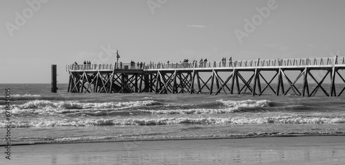 Black and white photo of the Saint-Jean-de-Monts pier, a monumental pontoon that flows into the ocean, Vendée, FRANCE.