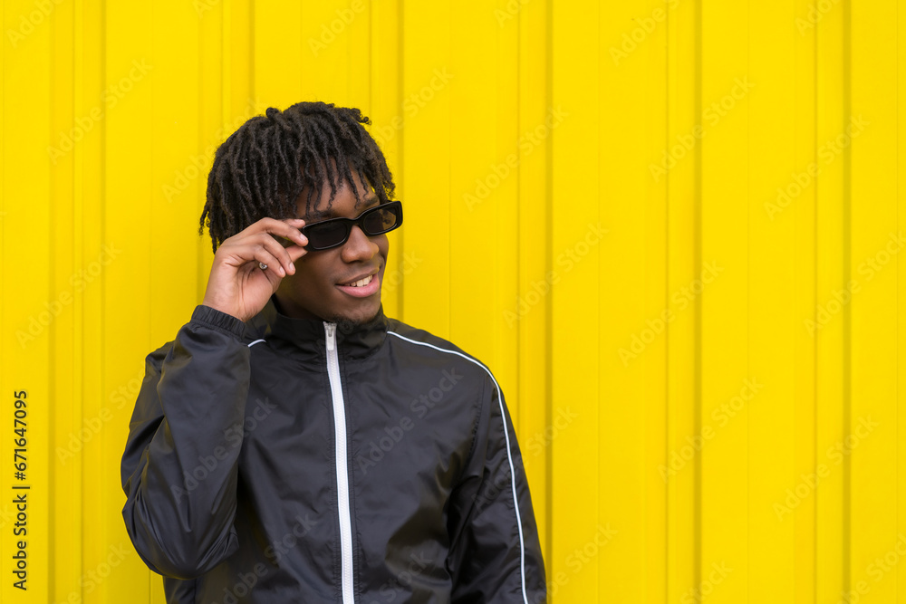 Fototapeta premium African young man wearing sunglasses with cool attitude outdoors