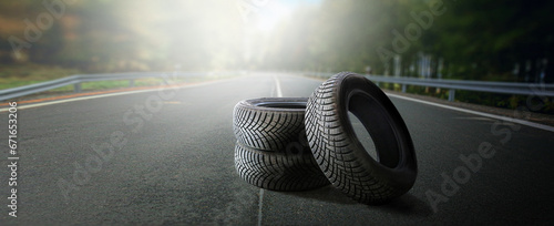 Winter tires on a asphalt road. Four wheel off. Change a summer tyre. Forest road with trees in blurred background. Change for new tire.