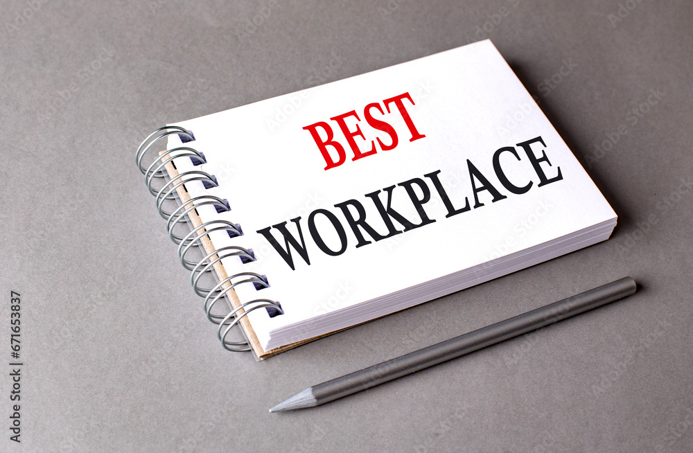 BEST WORKPLACE word on notebook on grey background BEST WORKPLACE word on notebook on grey background