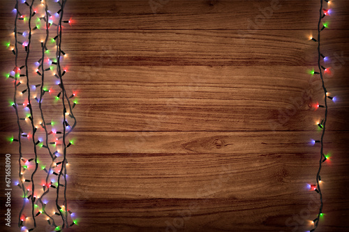 Christmas garland lights on wooden background. Christmas composition. Background for a New Year's poster with garlands. Shimmering multicolored garlands on a wooden background. Bright Garlands.