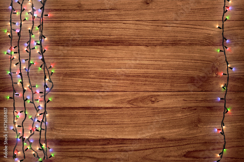 Christmas garland lights on wooden background. Christmas composition. Background for a New Year's poster with garlands. Shimmering multicolored garlands on a wooden background. Bright Garlands.